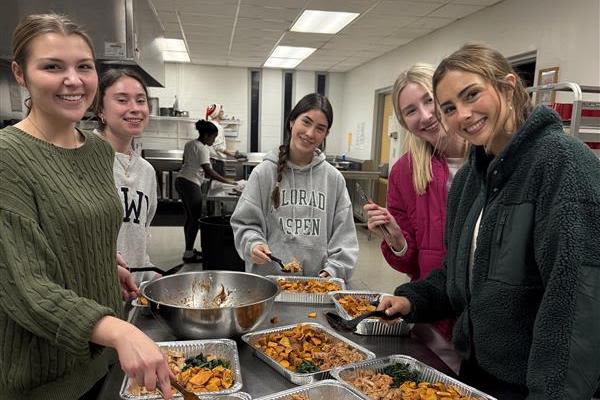 UGA student volunteers pause for a photo during a cooking shift in the kitchen