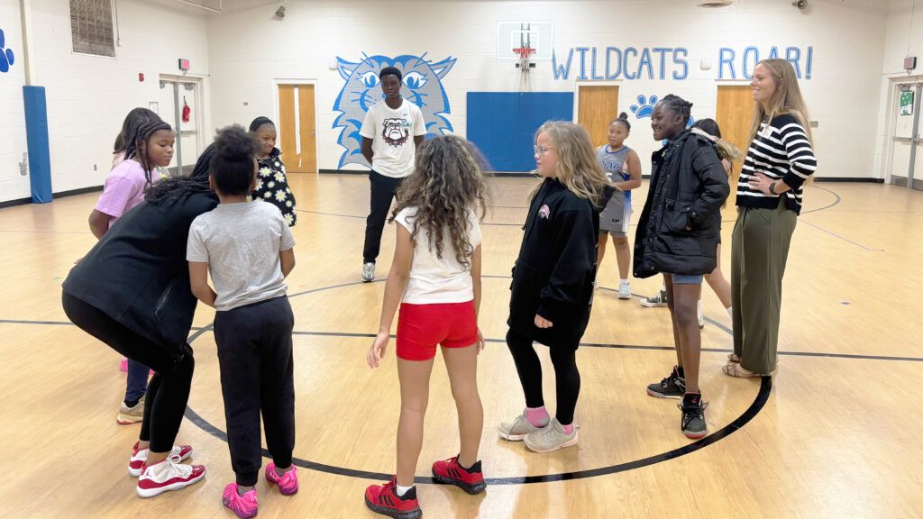 Coaching4Success mentors and CCSD students stand in a circle during an activity