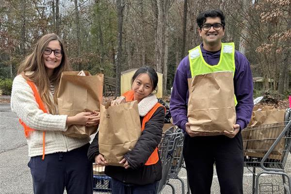 Campus Kitchen volunteers pose with grocery bags during a delivery shift
