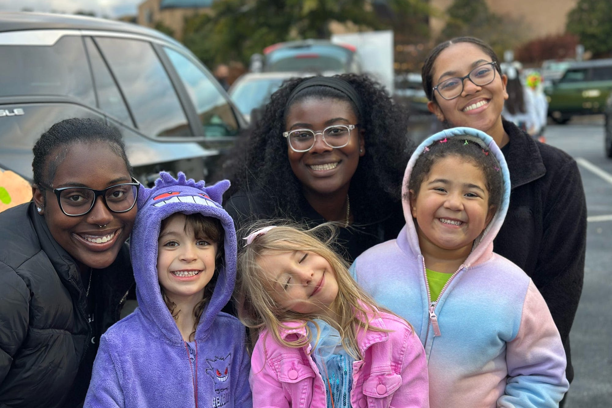 Experience UGA Ambassadors pose with kids during a Trunk or Treat Halloween event