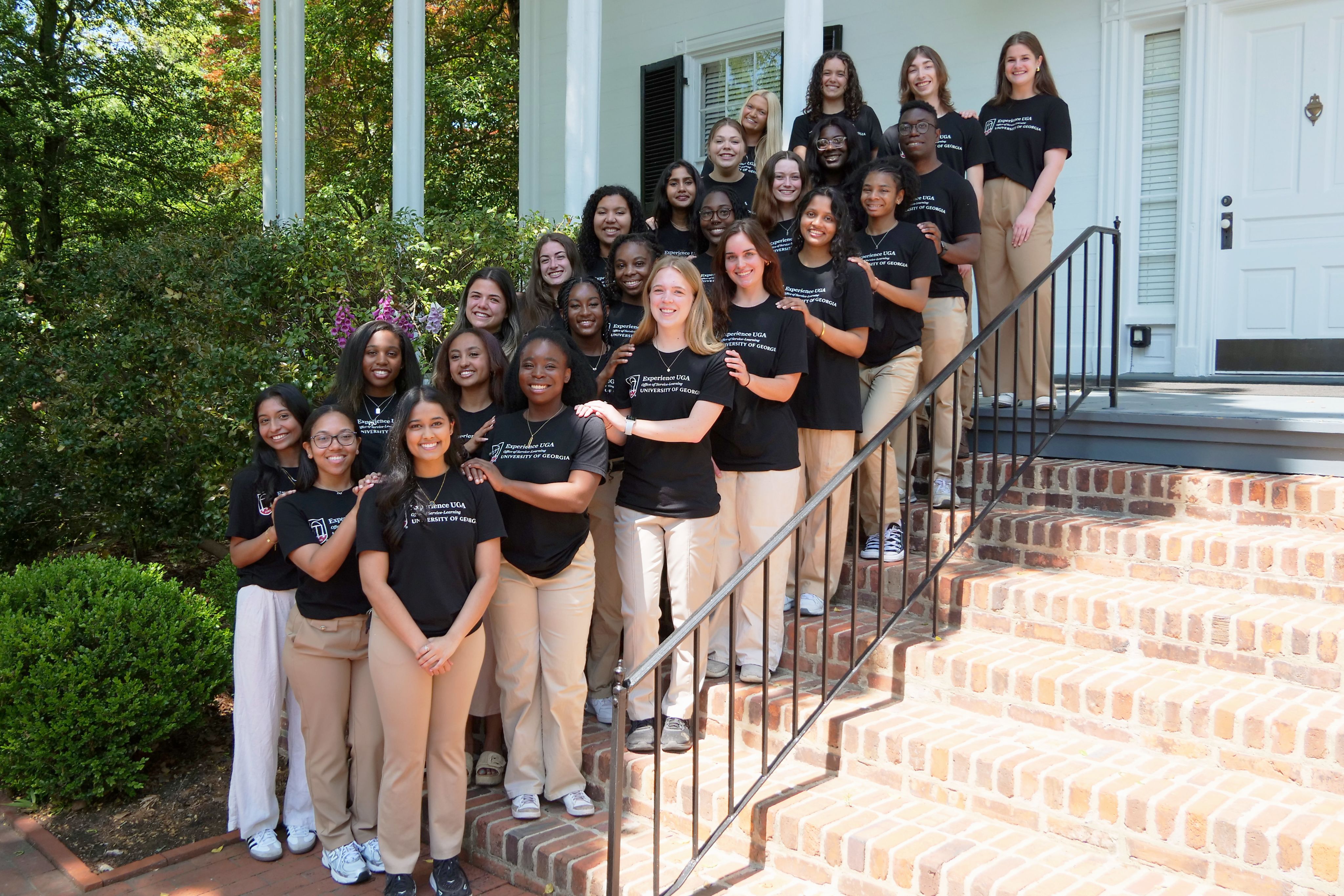 Experience UGA Ambassadors pose for a group photo on a brick staircase