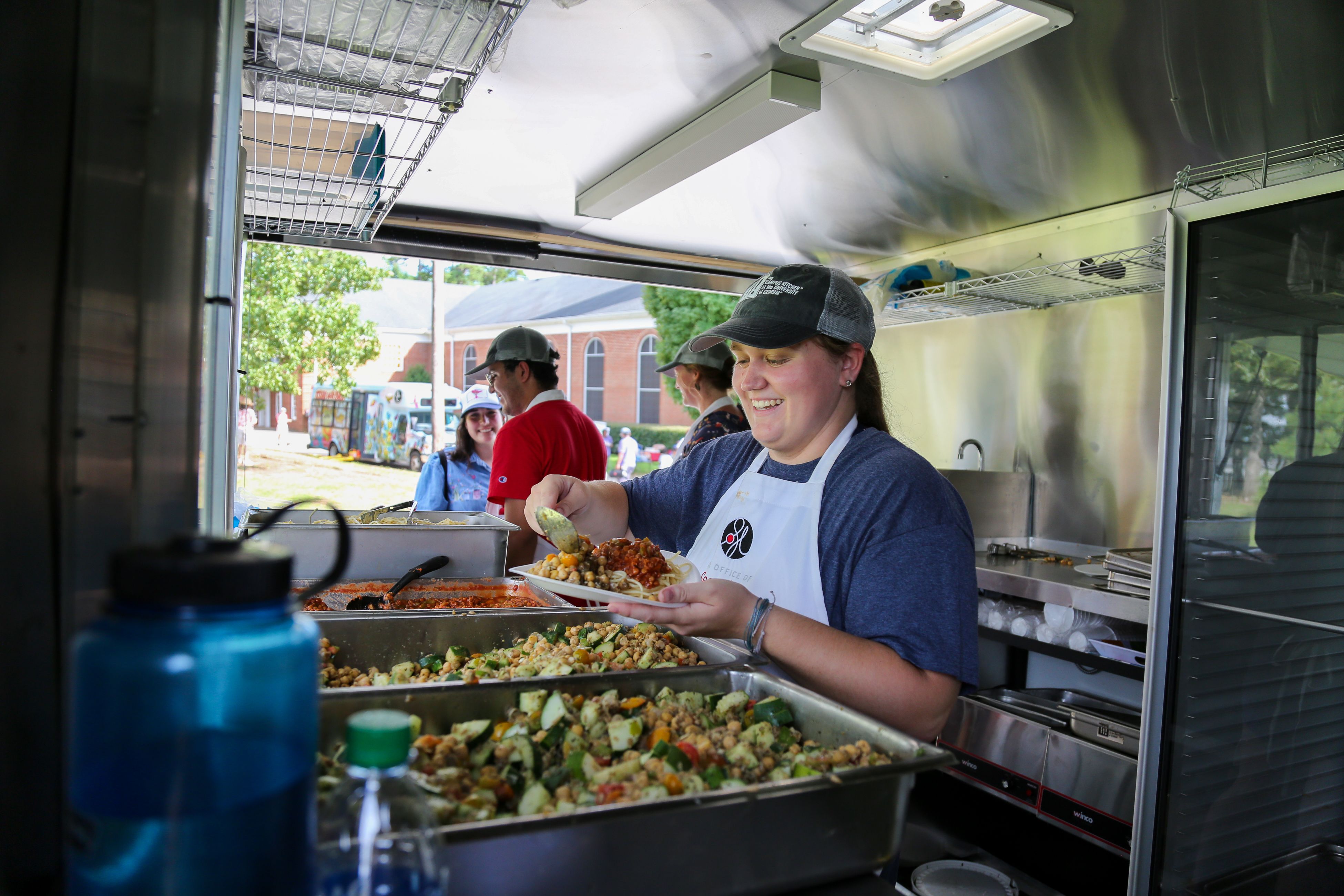 The Campus Kitchen Team prepares food in their trailer. 