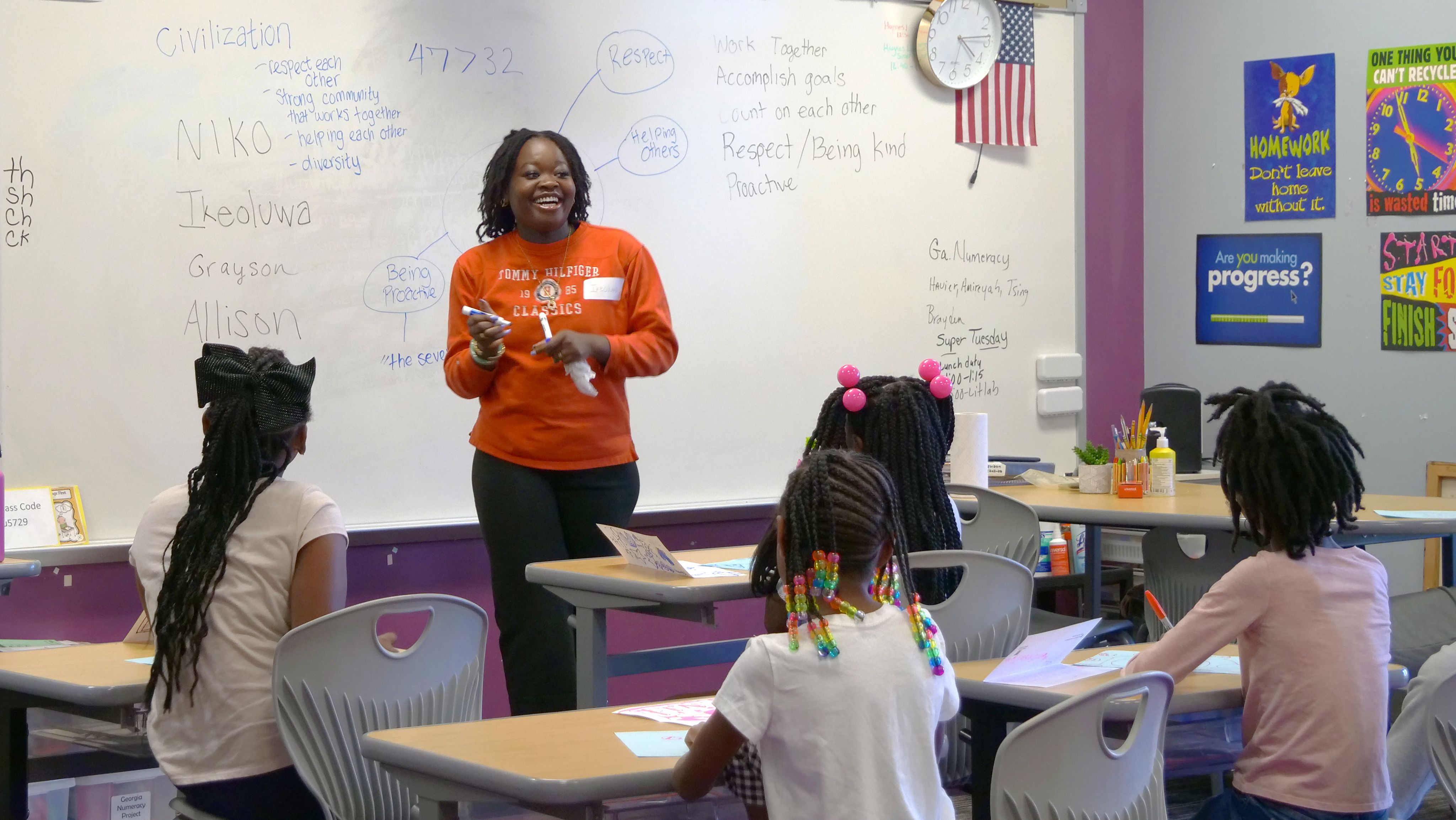 A UGA student laughs while meeting with elementary school students in the new sports and literacy tutoring program.