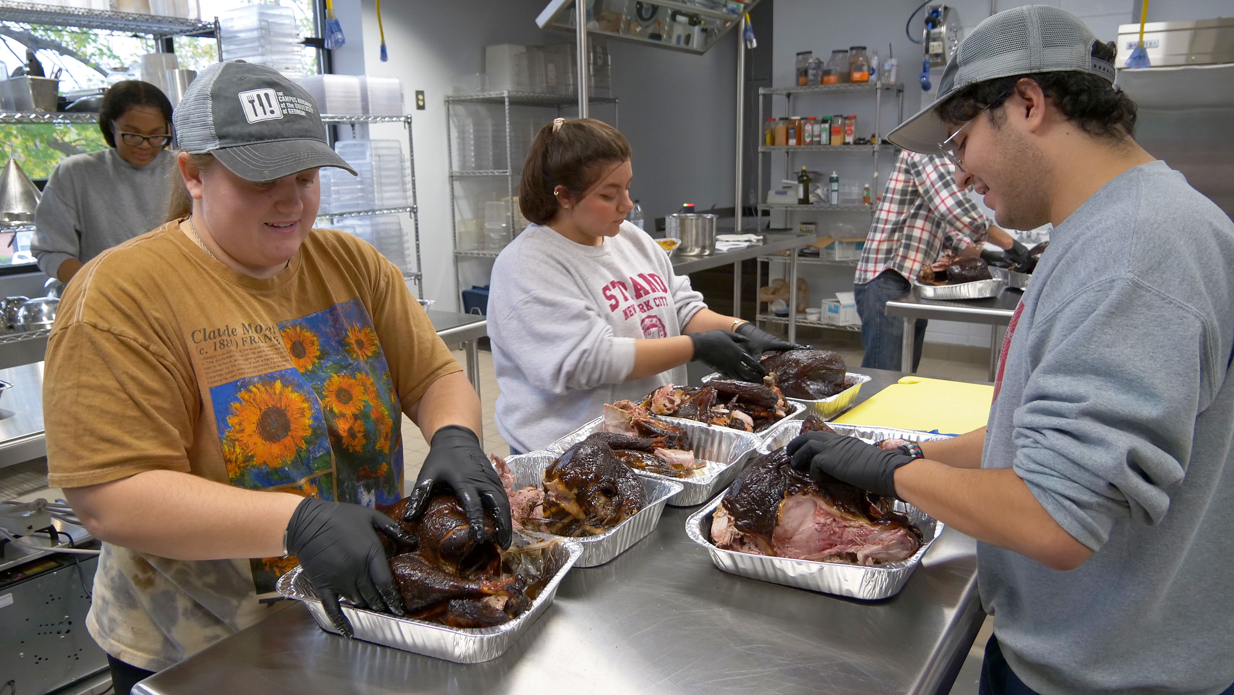 The Campus Kitchen team prepares the smoked turkeys at the Career Academy.