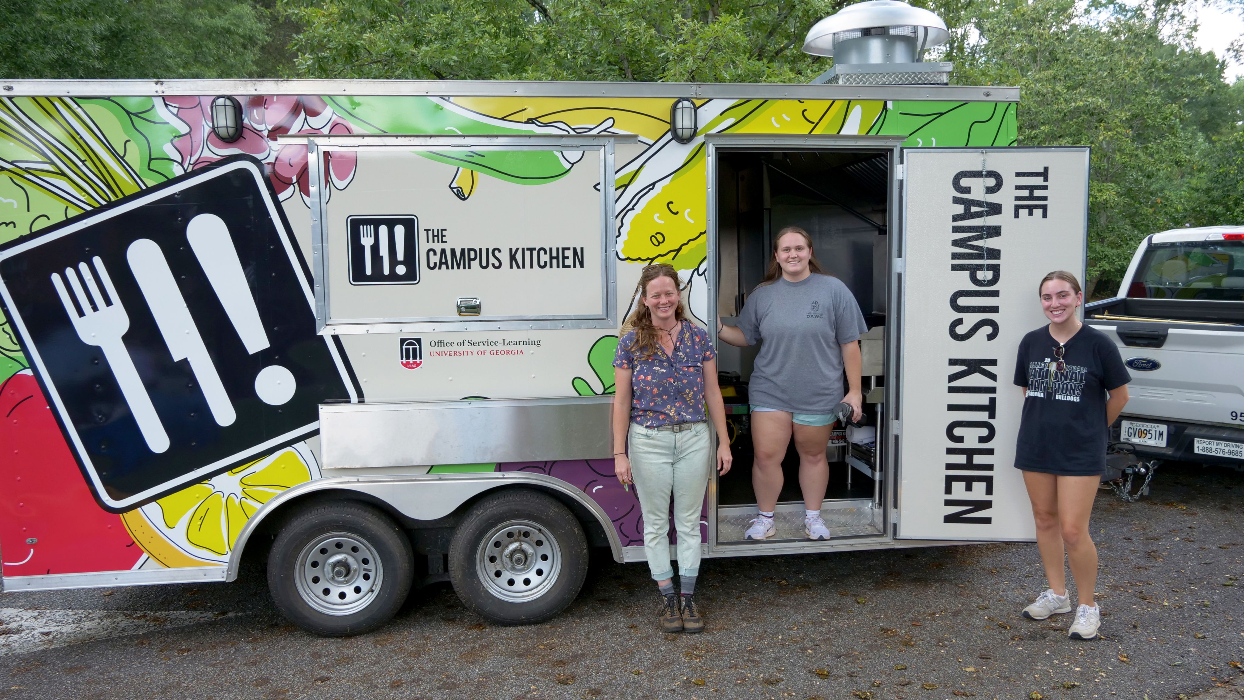 The Campus Kitchen team poses outside the trailer showing off its new colorful wrap.